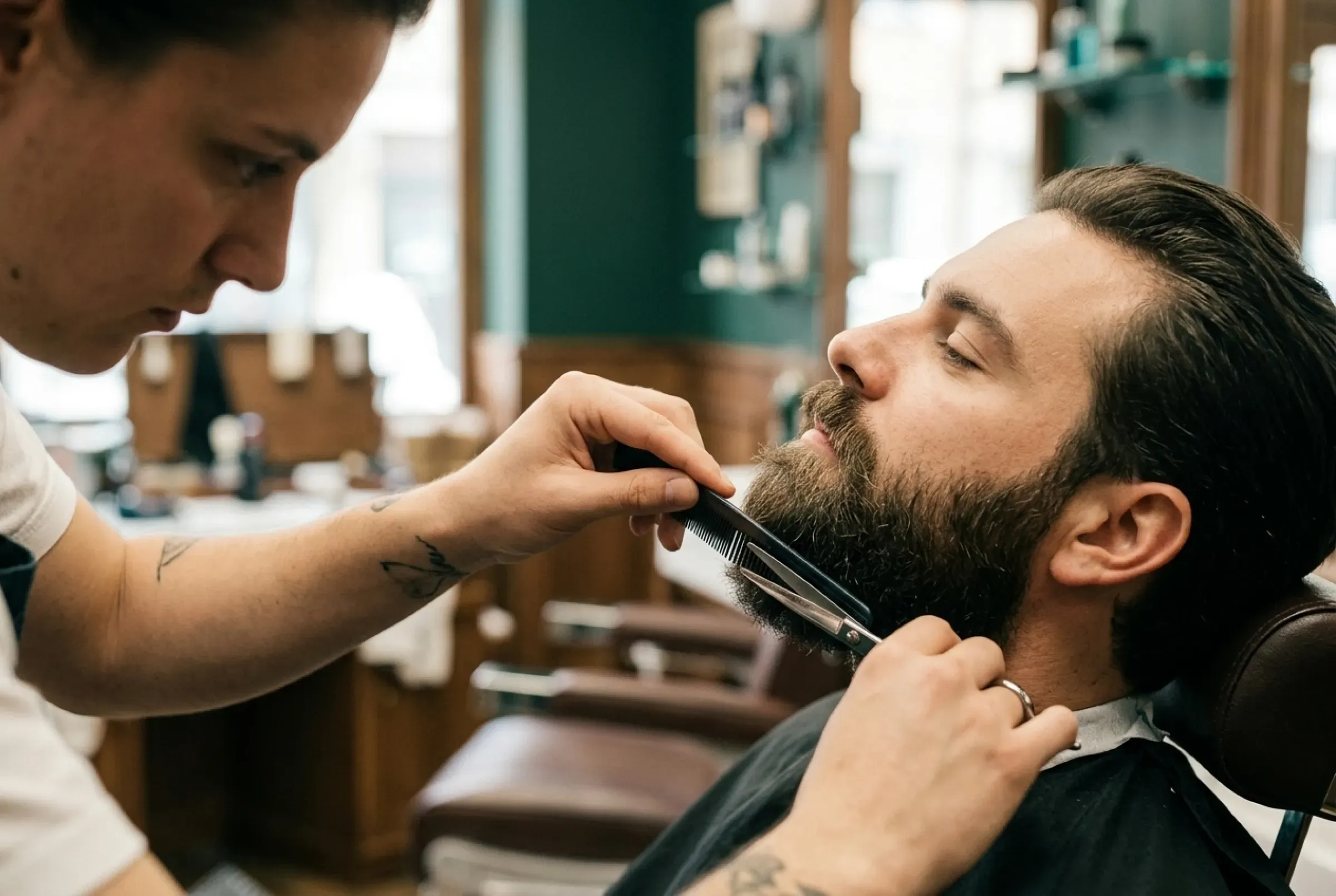 Barberare som klipper skägg med sax